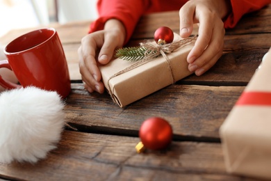 Photo of Woman with Christmas gift box at wooden table