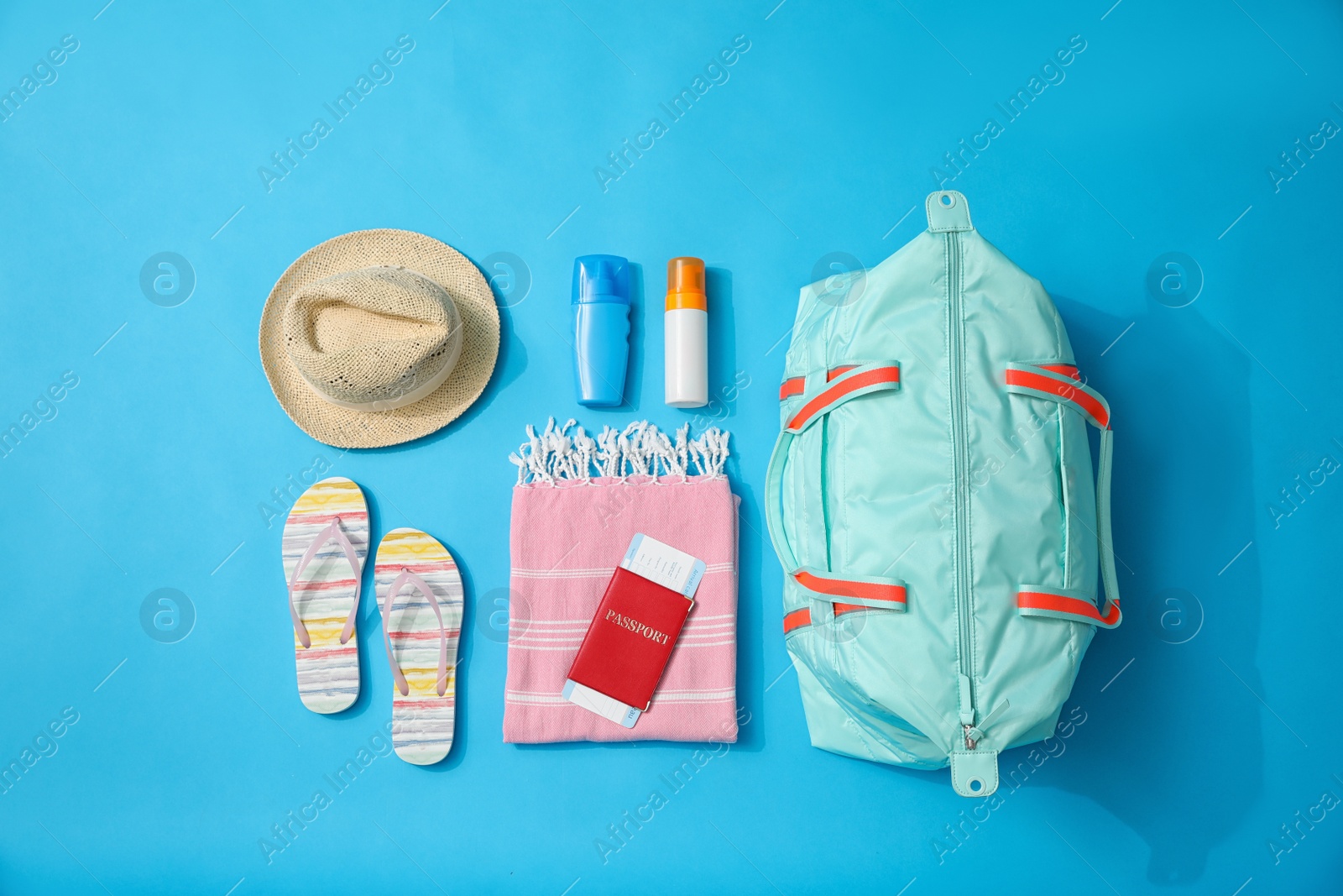 Photo of Flat lay composition with bag and travel accessories on blue background