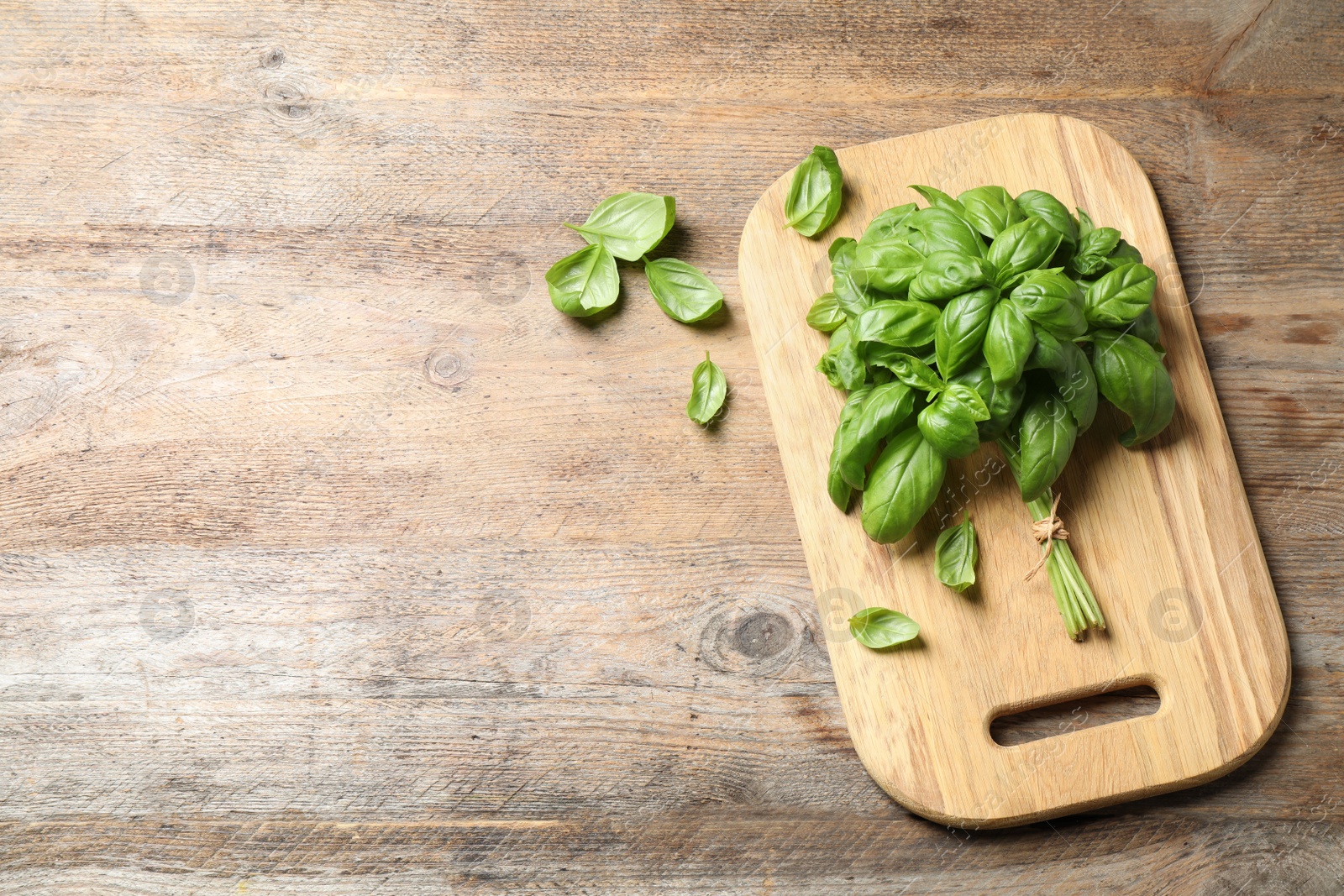 Photo of Fresh basil on wooden table, flat lay. Space for text