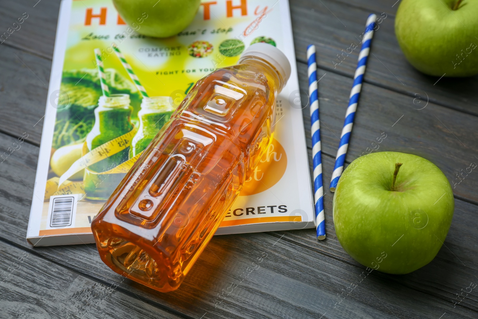 Photo of Bottle of fresh apple juice on wooden table