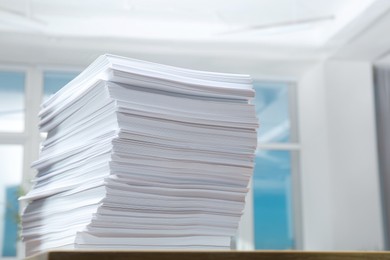 Stack of paper sheets on wooden table indoors. Space for text