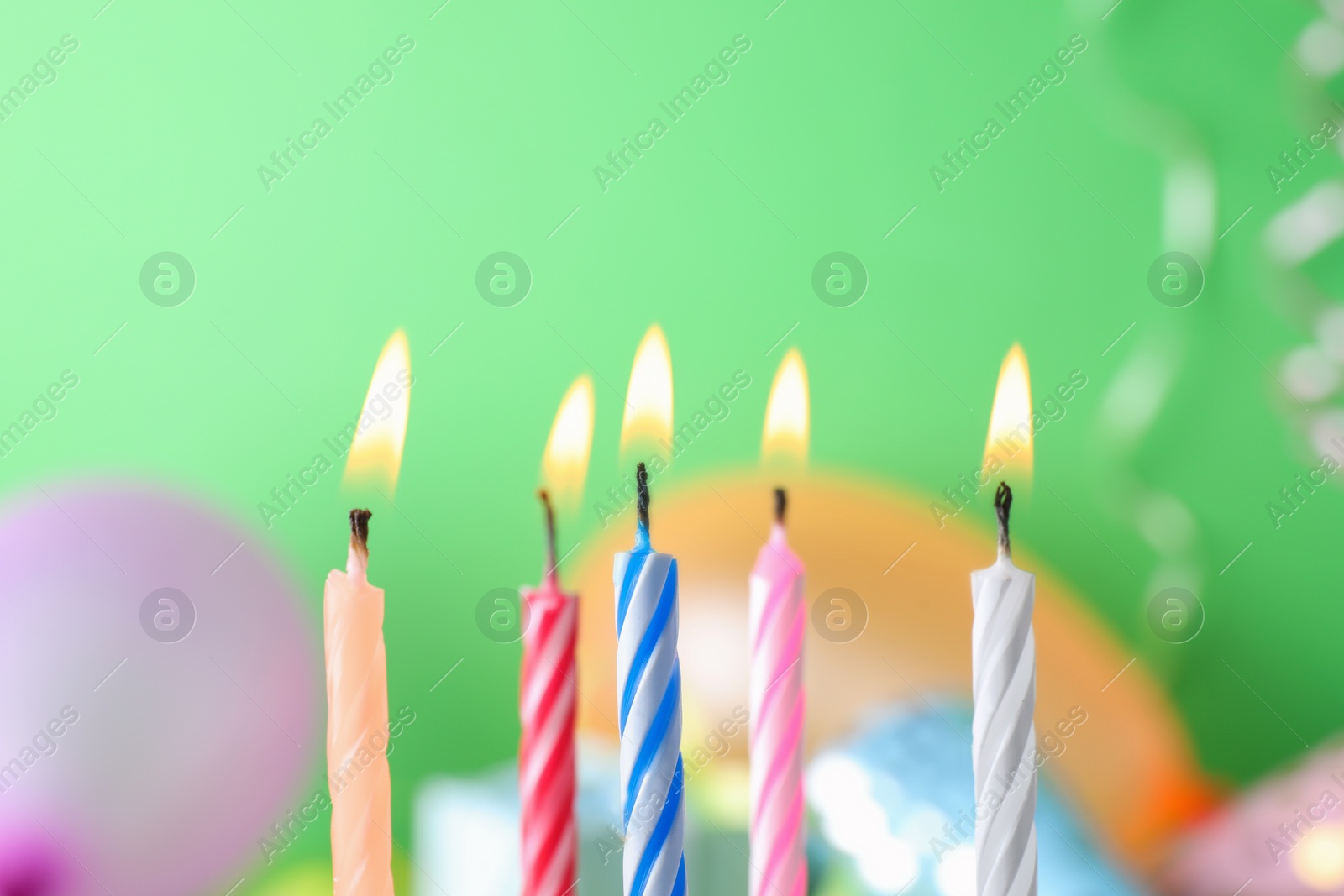 Photo of Burning birthday cake candles on color background. Space for text