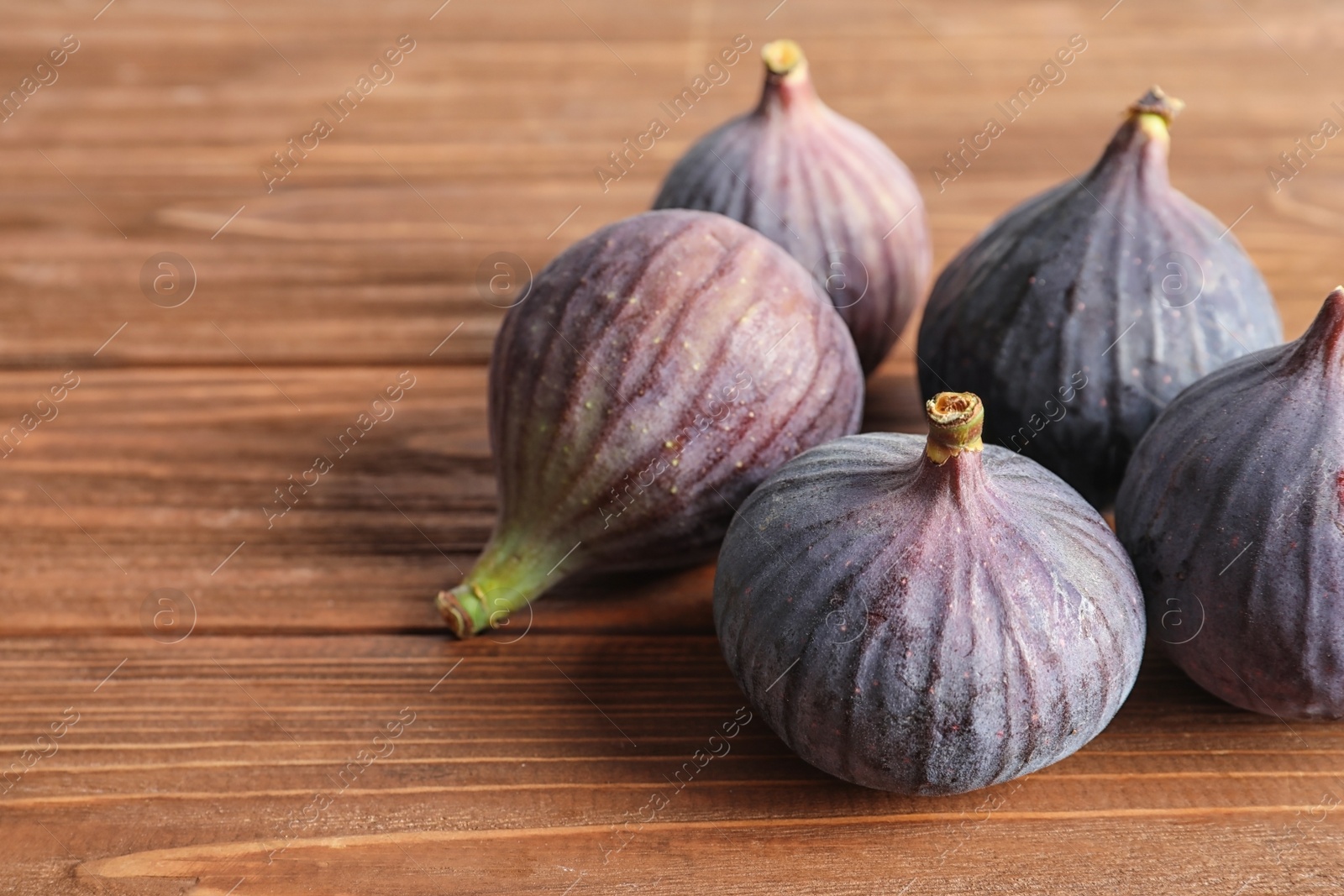 Photo of Ripe sweet figs on wooden background. Tropical fruit