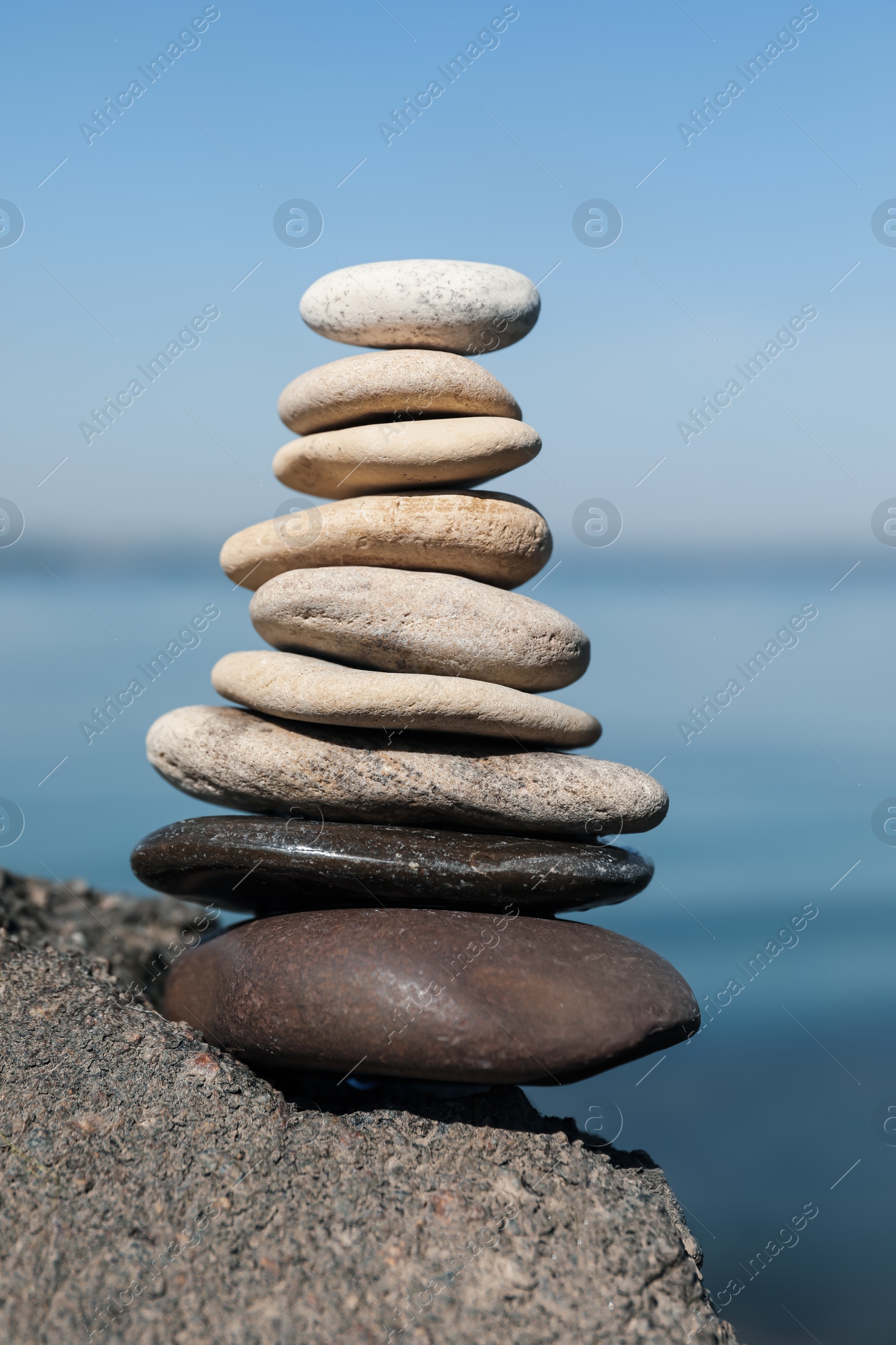 Photo of Stack of stones on rock near sea. Harmony and balance concept