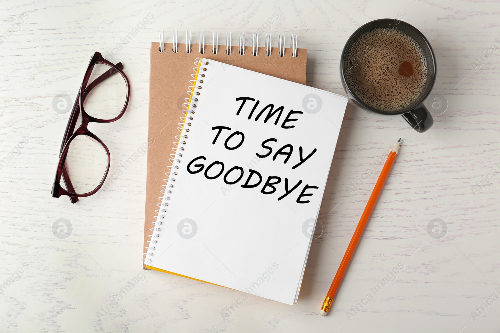 Image of Notebook with text Time to say goodbye, office stationery and cup of coffee on white wooden table, flat lay