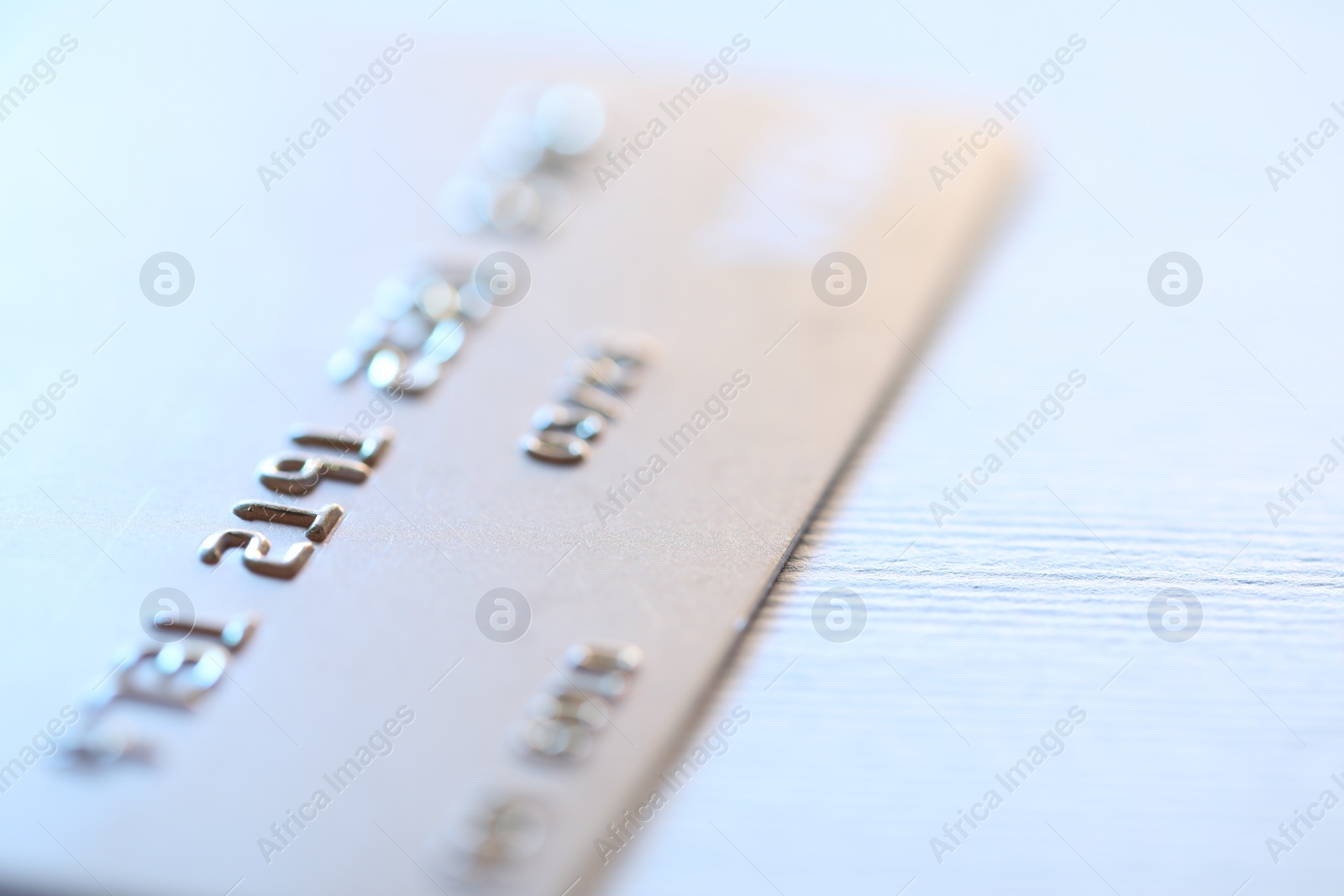 Photo of One credit card on light background, macro view. Space for text