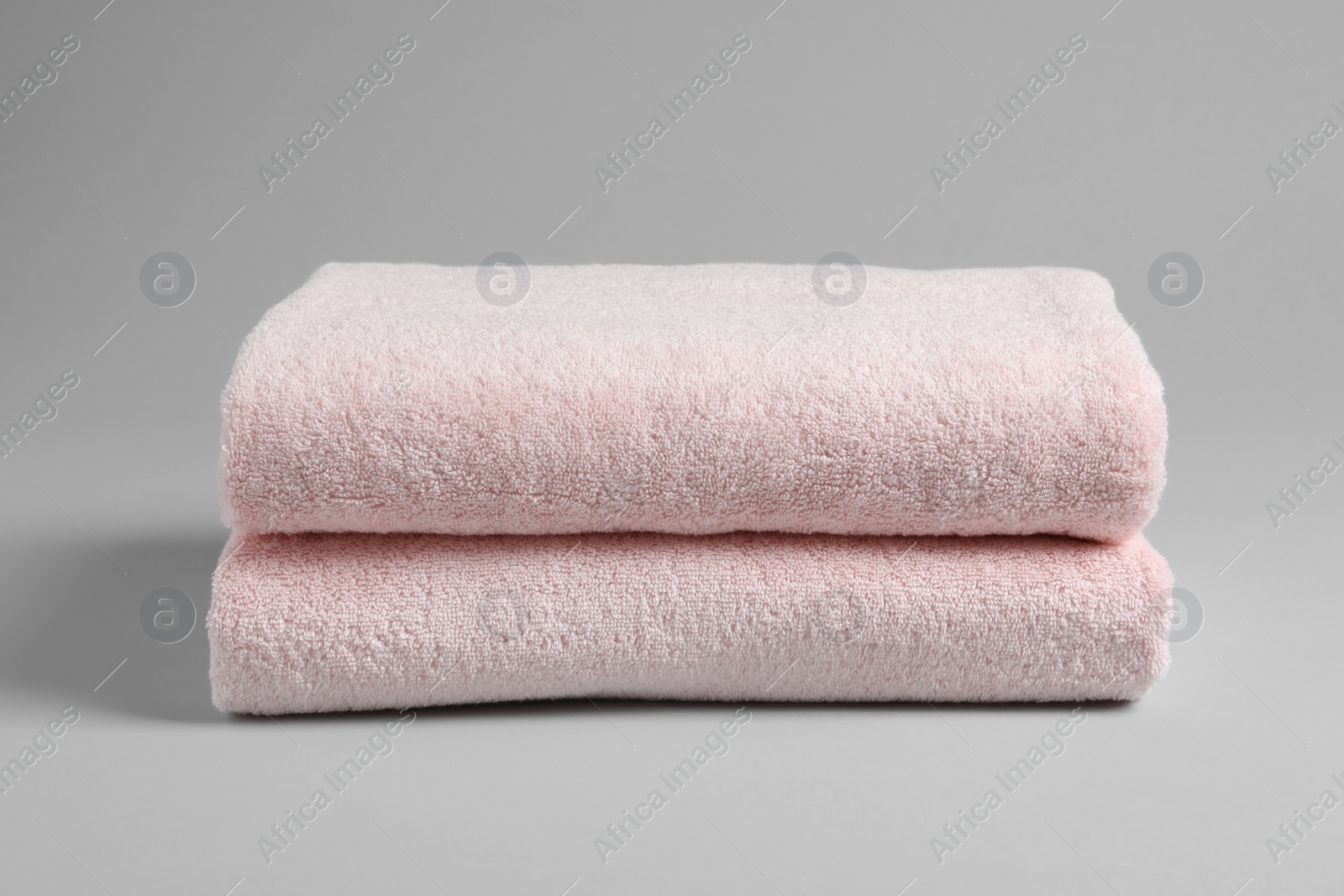 Photo of Fresh soft folded towels on light background