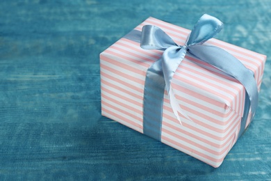 Elegant gift box with bow on wooden background