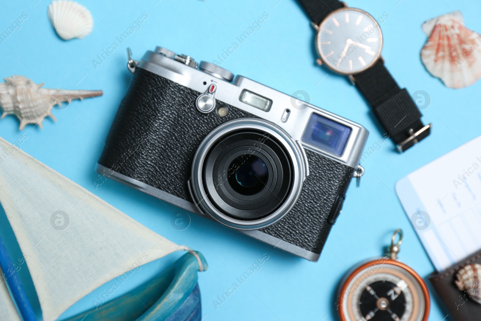 Photo of Flat lay composition with camera, passport and exotic seashells on color background. Professional photography