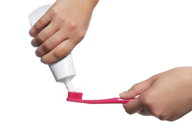 Woman applying toothpaste on brush against white background, closeup