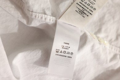 Clothing label in Chinese language on white garment, closeup