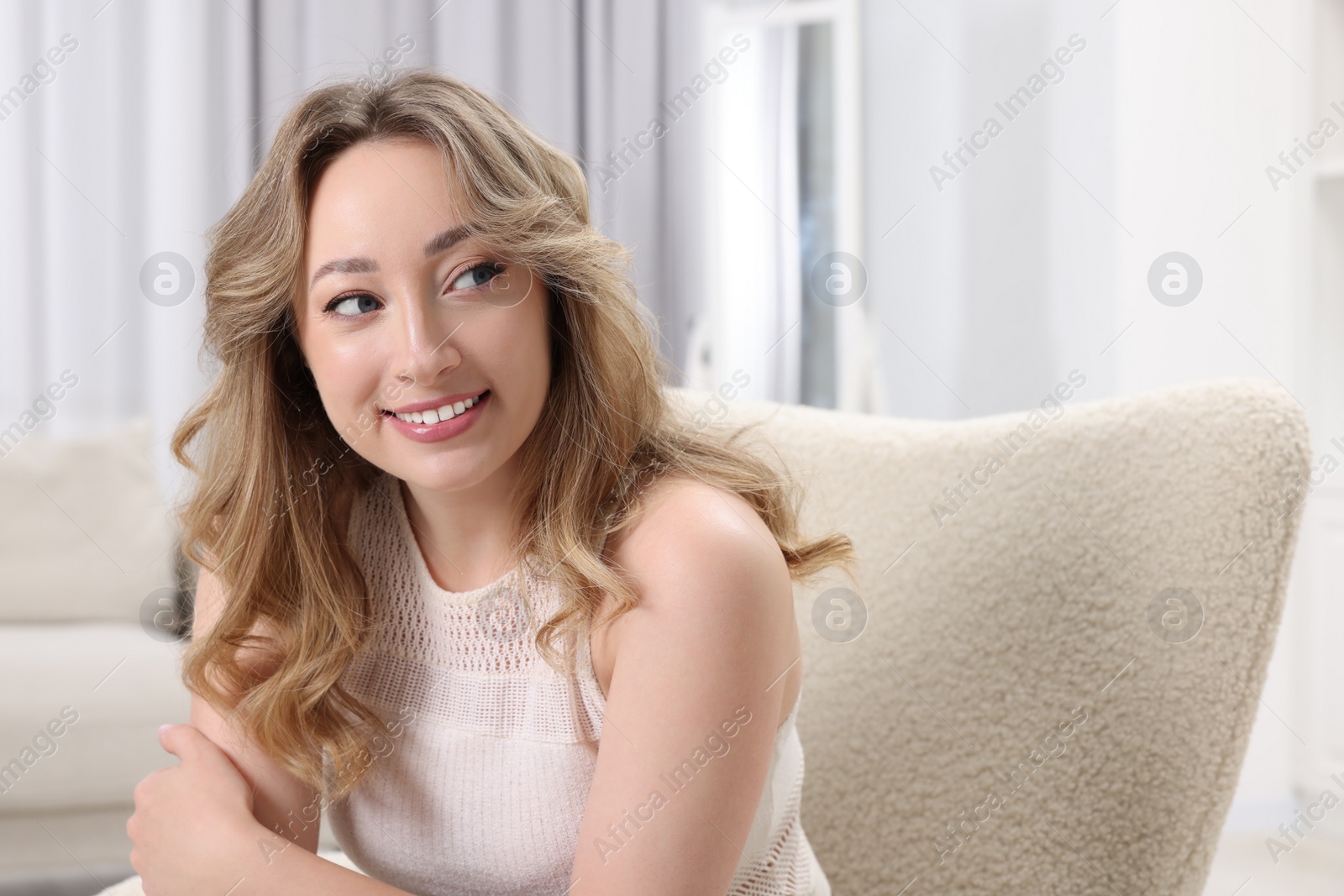 Photo of Portrait of smiling woman with curly hair at home. Space for text