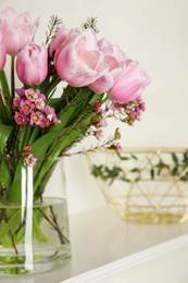 Photo of Beautiful bouquet with spring pink tulips on shelf