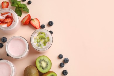 Jars of fresh yogurt and different fruits on light pink background, flat lay. Space for text