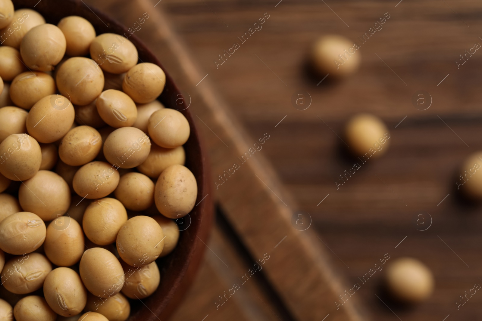 Photo of Natural soy beans on wooden table, closeup. Space for text