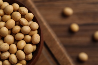 Natural soy beans on wooden table, closeup. Space for text