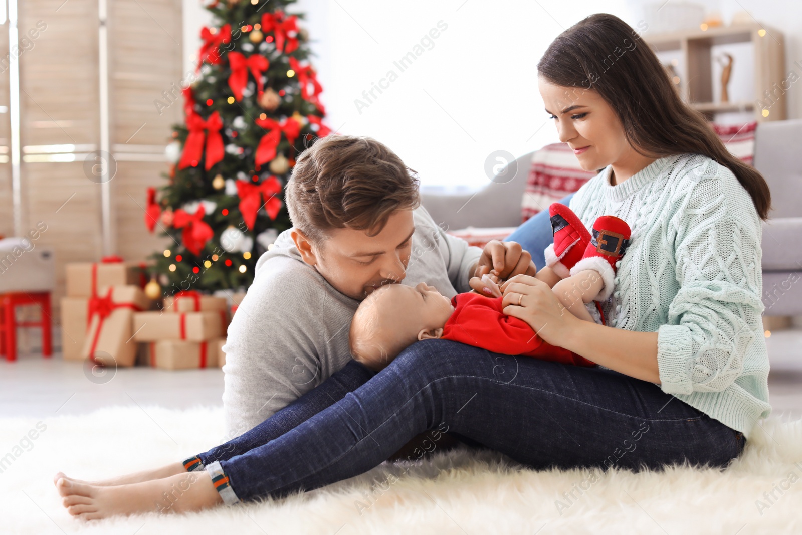 Photo of Happy couple with baby celebrating Christmas together at home