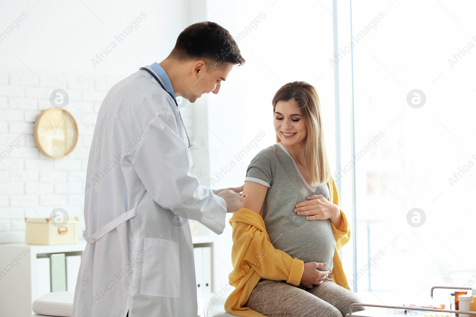 Photo of Doctor vaccinating pregnant woman in clinic
