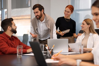 Photo of Team of employees working together in office