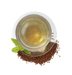 Photo of Cup of aromatic buckwheat tea, granules and mint on white background, top view