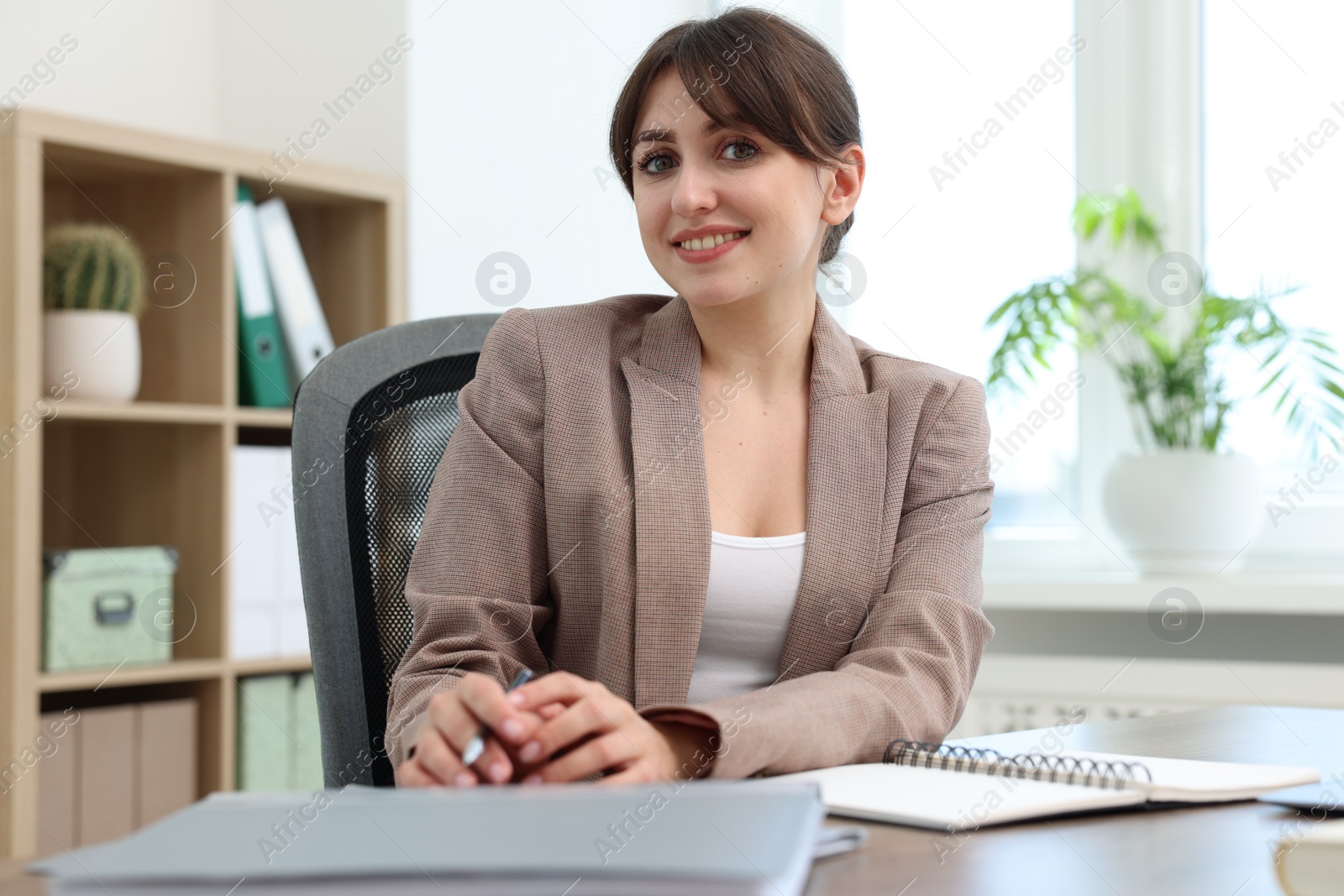 Photo of Portrait of smiling secretary at table in office