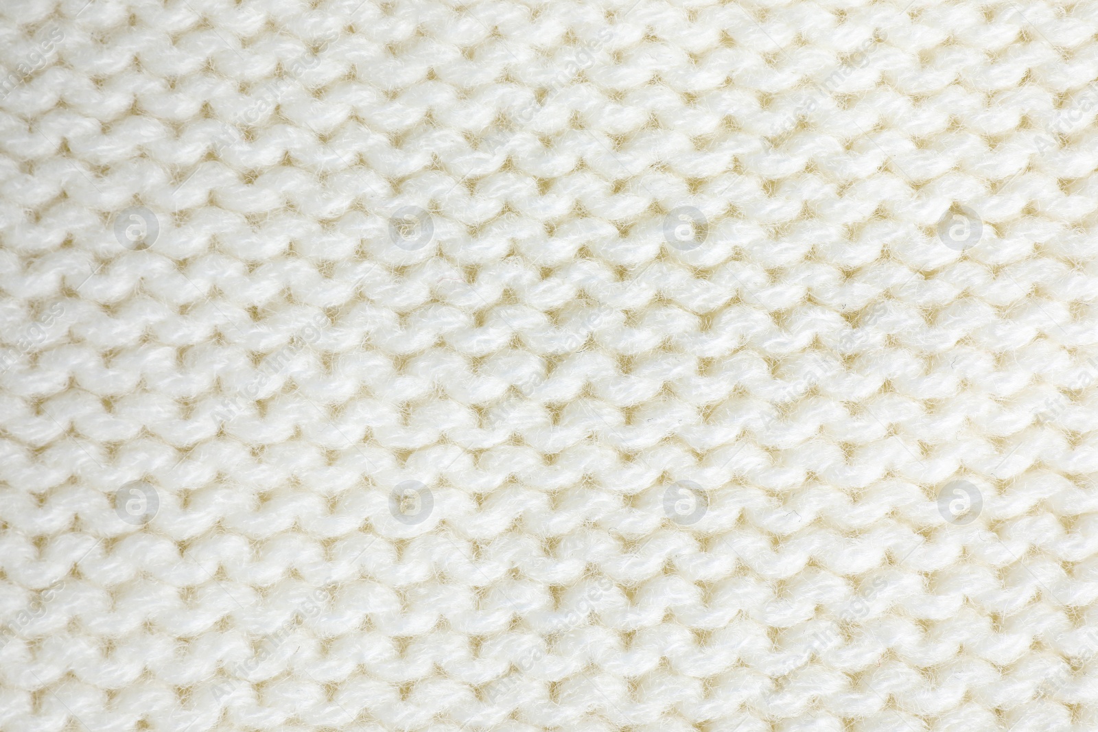 Photo of White knitted sweater as background, closeup view