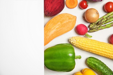 Flat lay composition with fresh vegetables and blank card for text on light background