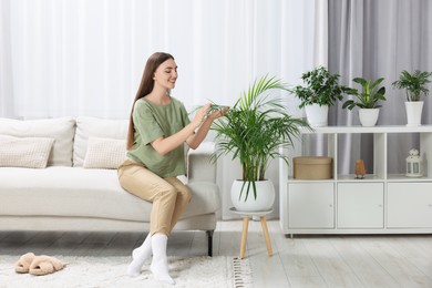 Beautiful young woman in room with green houseplants
