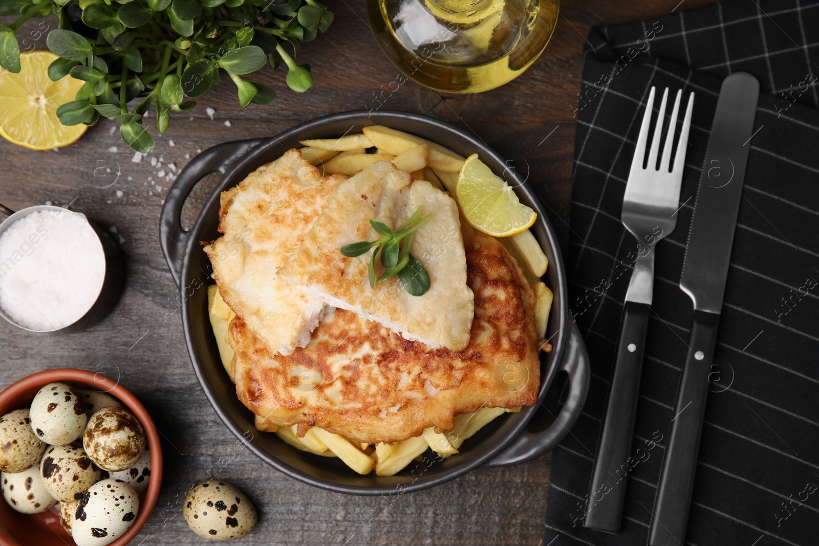 Photo of Tasty soda water battered fish, potato chips and lemon slice served on wooden table, flat lay