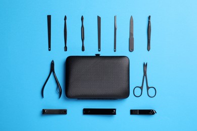 Photo of Manicure tools and case on light blue background, flat lay