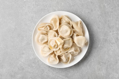 Photo of Tasty dumplings with butter on grey table, top view