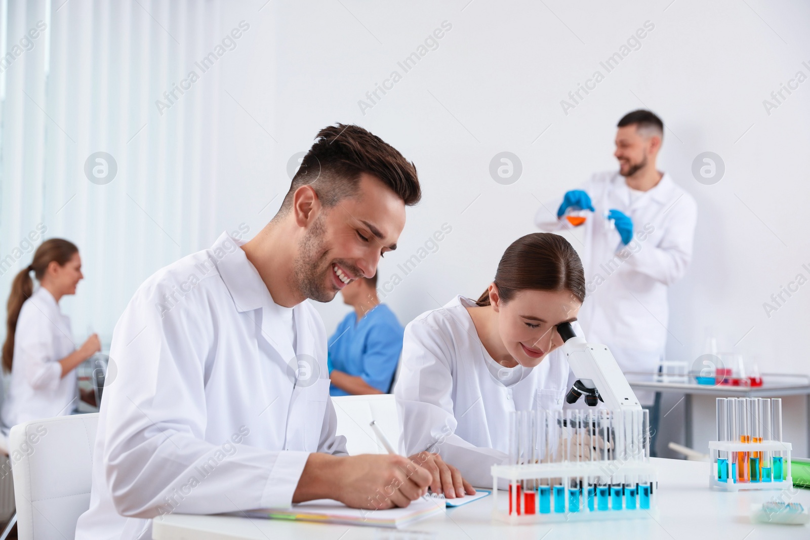 Photo of Medical students with microscope in modern laboratory