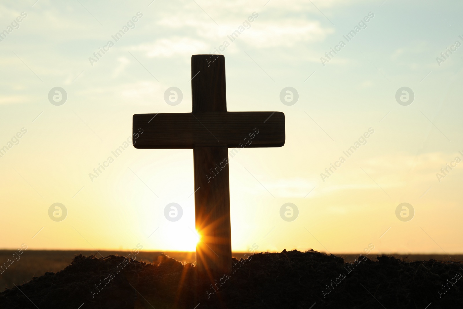 Photo of Silhouette of Christian cross outdoors at sunrise. Religion concept