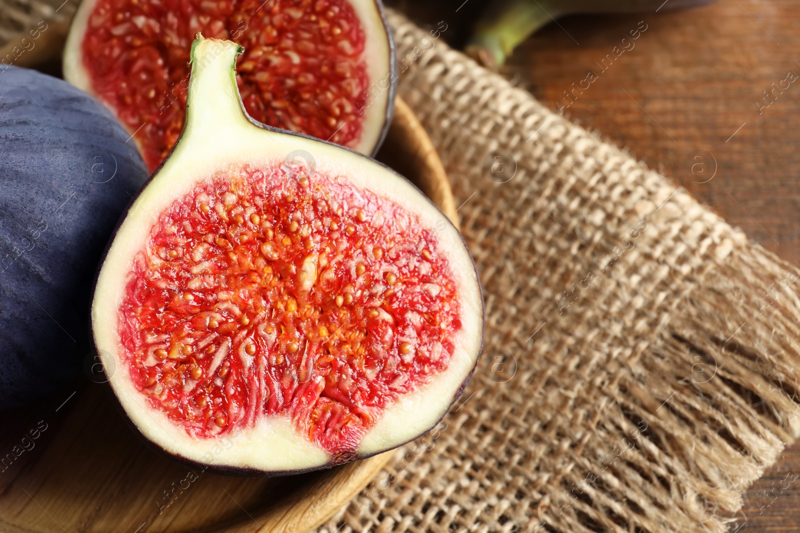 Photo of Plate with fresh ripe figs on wooden background, closeup