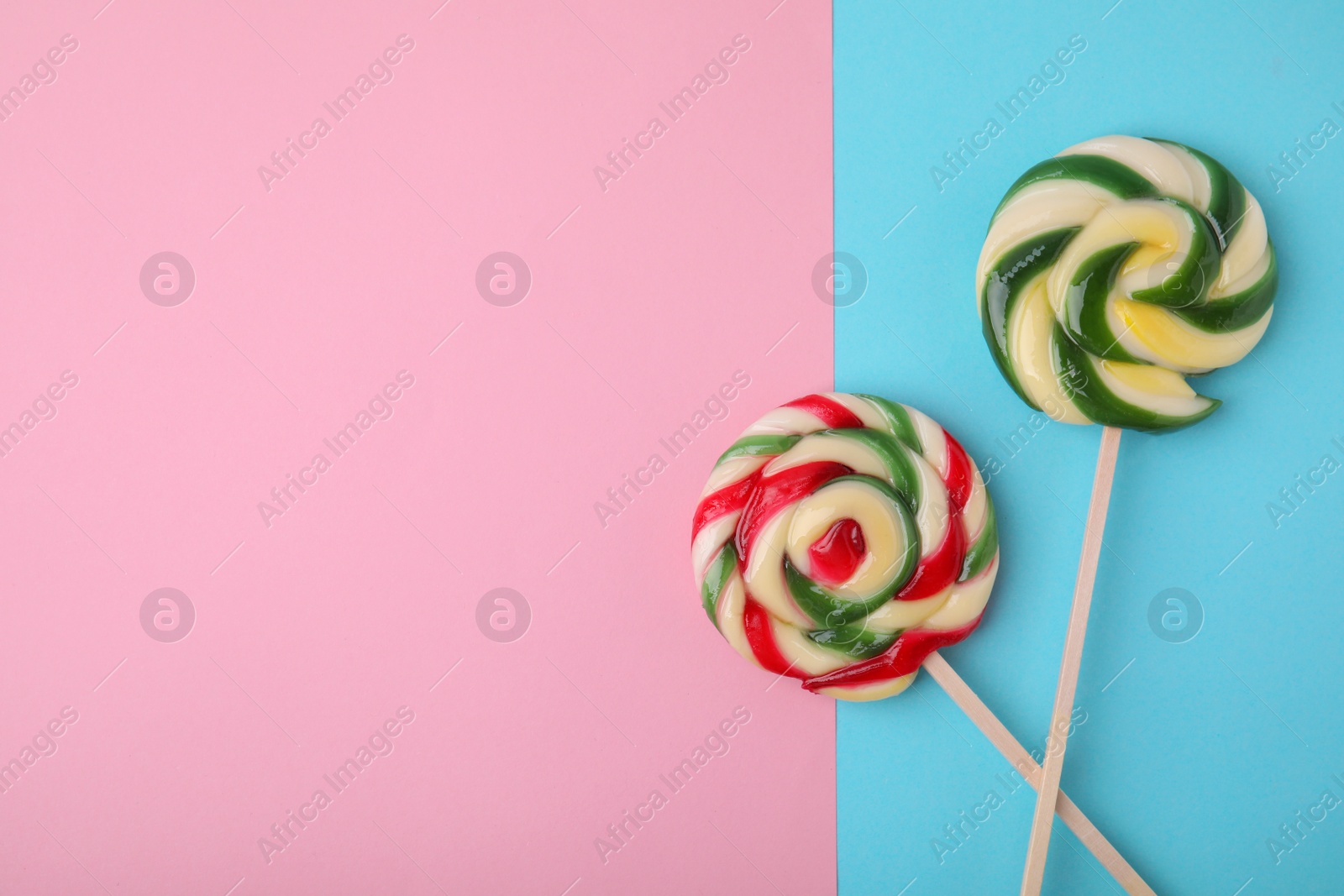 Photo of Sweet lollipops on color background, flat lay. Space for text