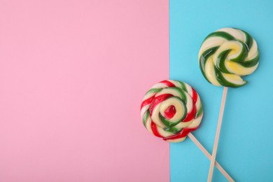 Sweet lollipops on color background, flat lay. Space for text