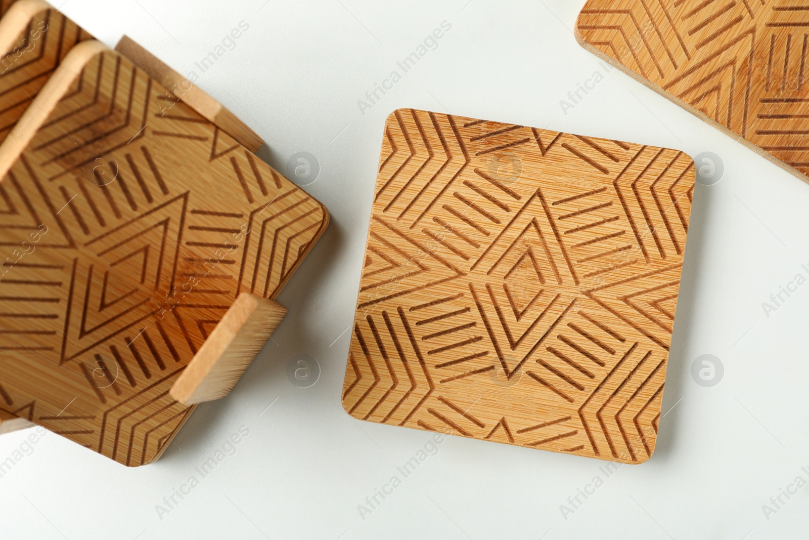 Photo of Stylish wooden cup coasters on white table, flat lay