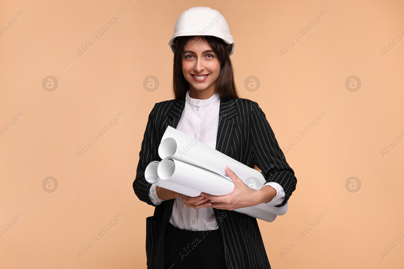 Photo of Architect in hard hat with drafts on beige background