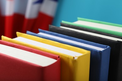 Learning foreign language. Different books and flag of United Kingdom on light blue background, closeup
