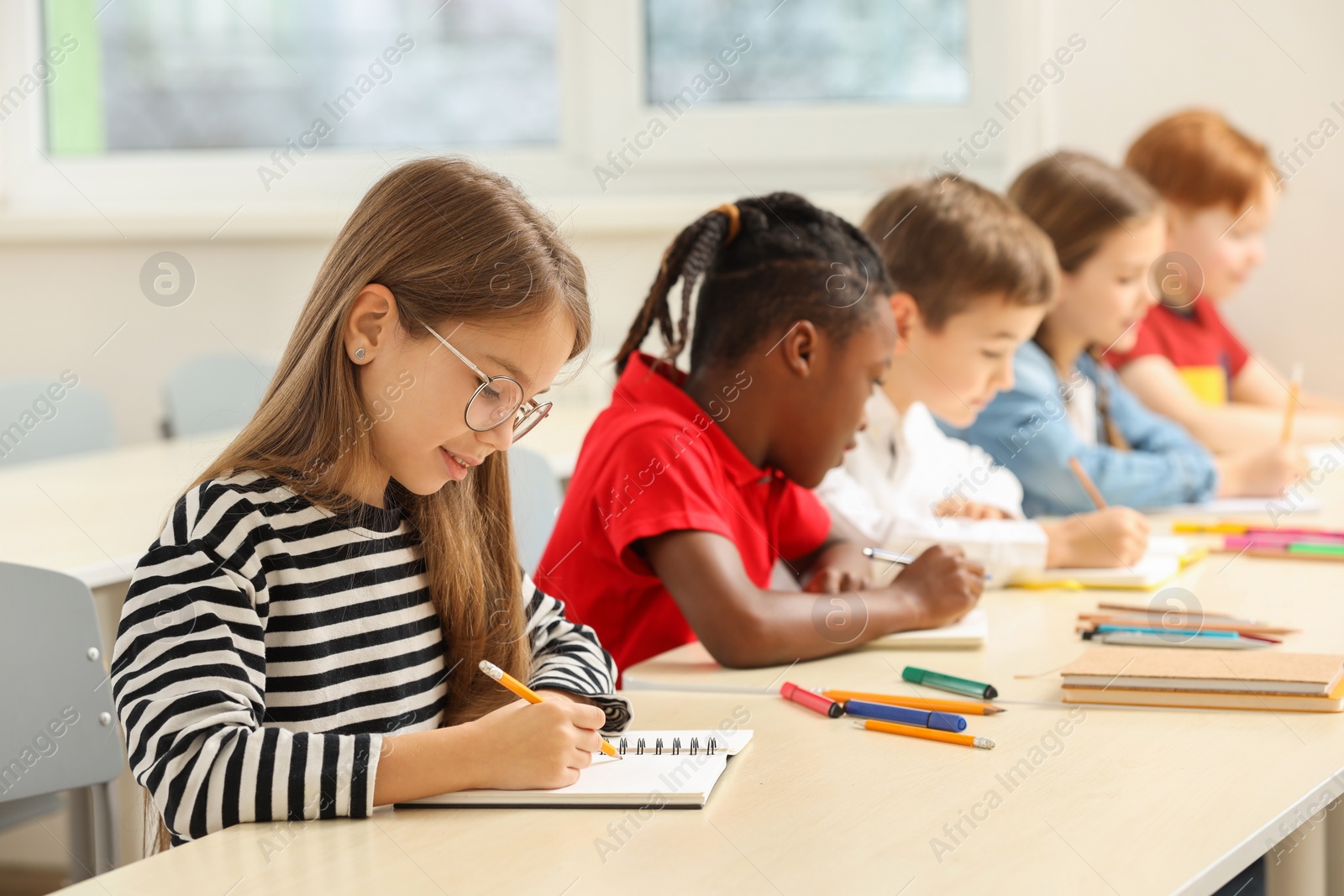 Photo of Cute children studying in classroom at school