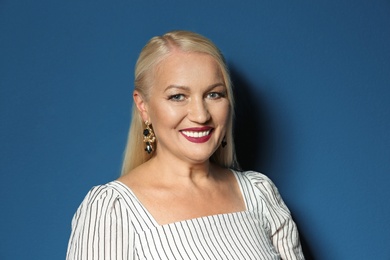 Portrait of beautiful mature woman on blue background