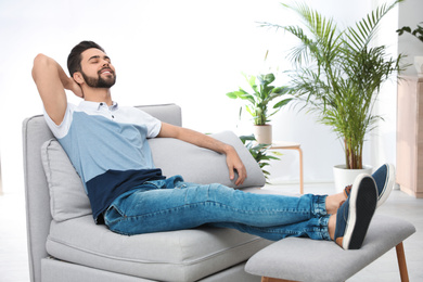 Photo of Young man relaxing on couch at home