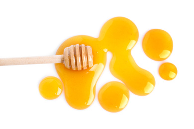 Photo of Drops of honey and dipper on white background, top view