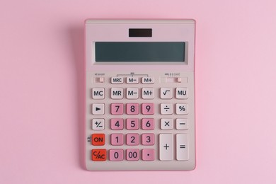 Modern calculator on pink background, top view