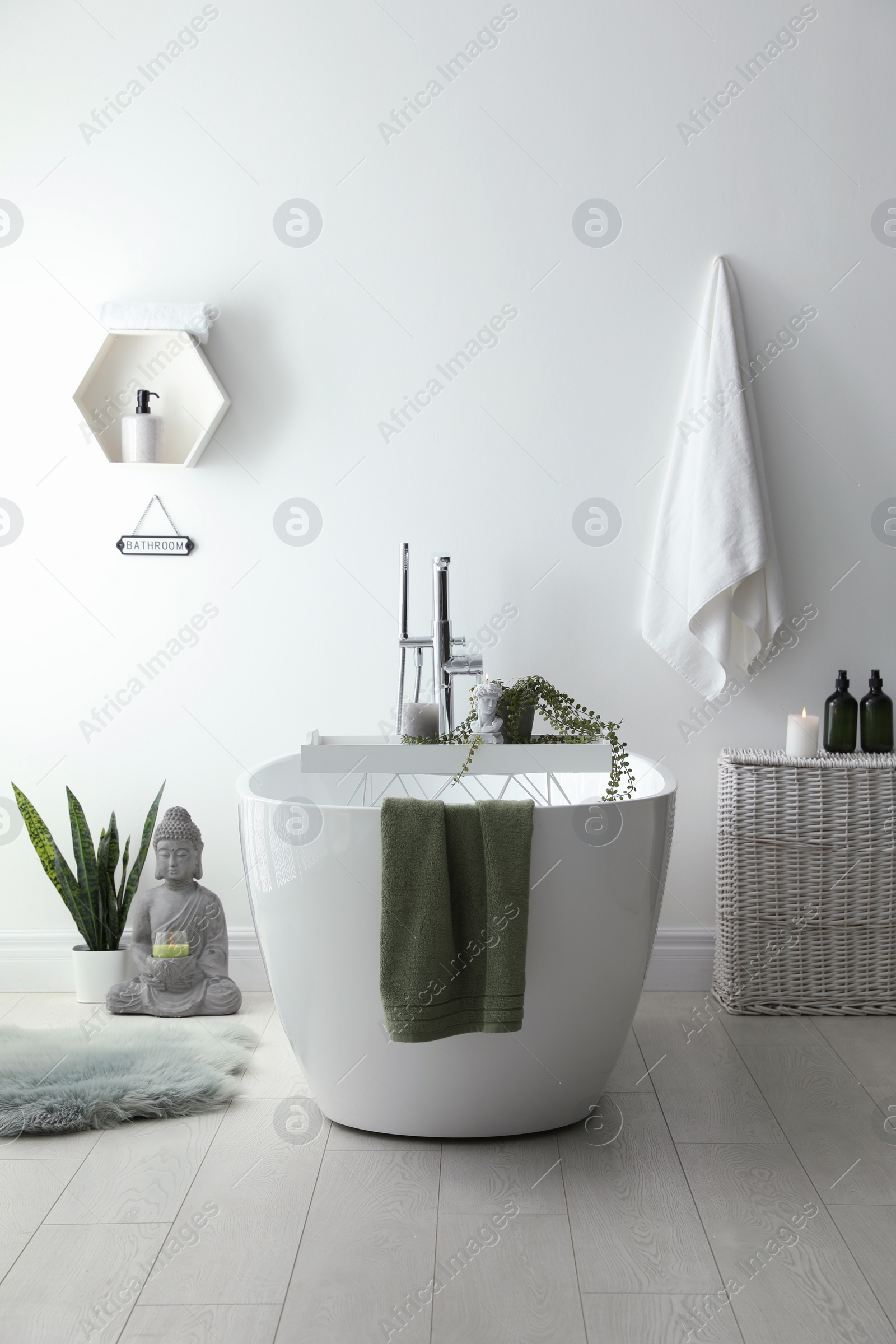 Photo of Stylish bathroom interior with modern tub, houseplants and beautiful decor. Home design