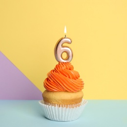 Birthday cupcake with number six candle on color background