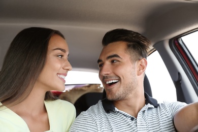 Happy young couple in car on road trip