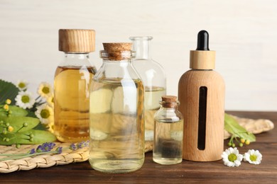 Aromatherapy. Different essential oils and flowers on wooden table