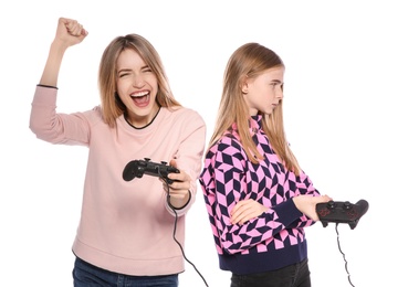 Young woman and teenage girl playing video games with controllers isolated on white