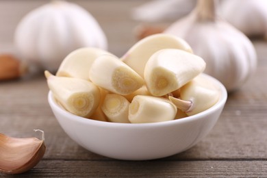 Aromatic garlic cloves and bulbs on wooden table, closeup